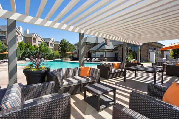 Scenic outdoor pool area at Aspen Ridge Apartments with luxurious seating and vibrant landscaping