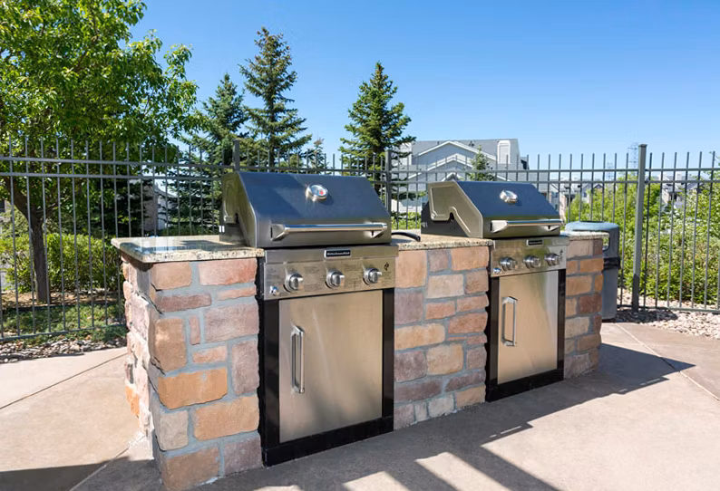 Outdoor grill area with modern seating at Aspen Ridge Apartments, offering a perfect gathering space for residents and guests