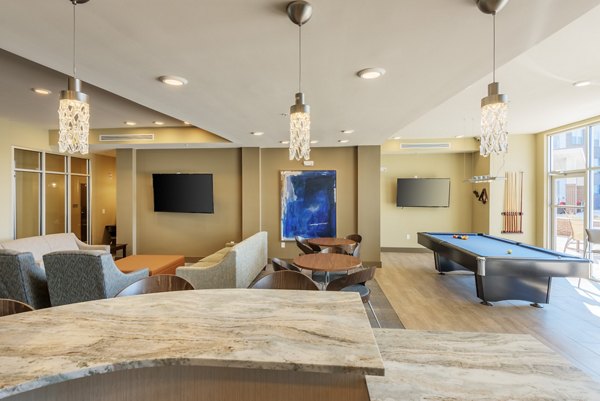 â€œModern lounge area with pool table, seating, and TV in luxury apartmentsâ€