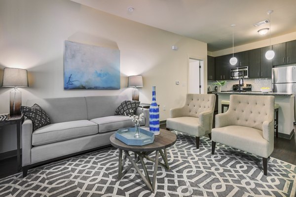 Modern living room with gray sofa and beige armchairs at luxury apartments