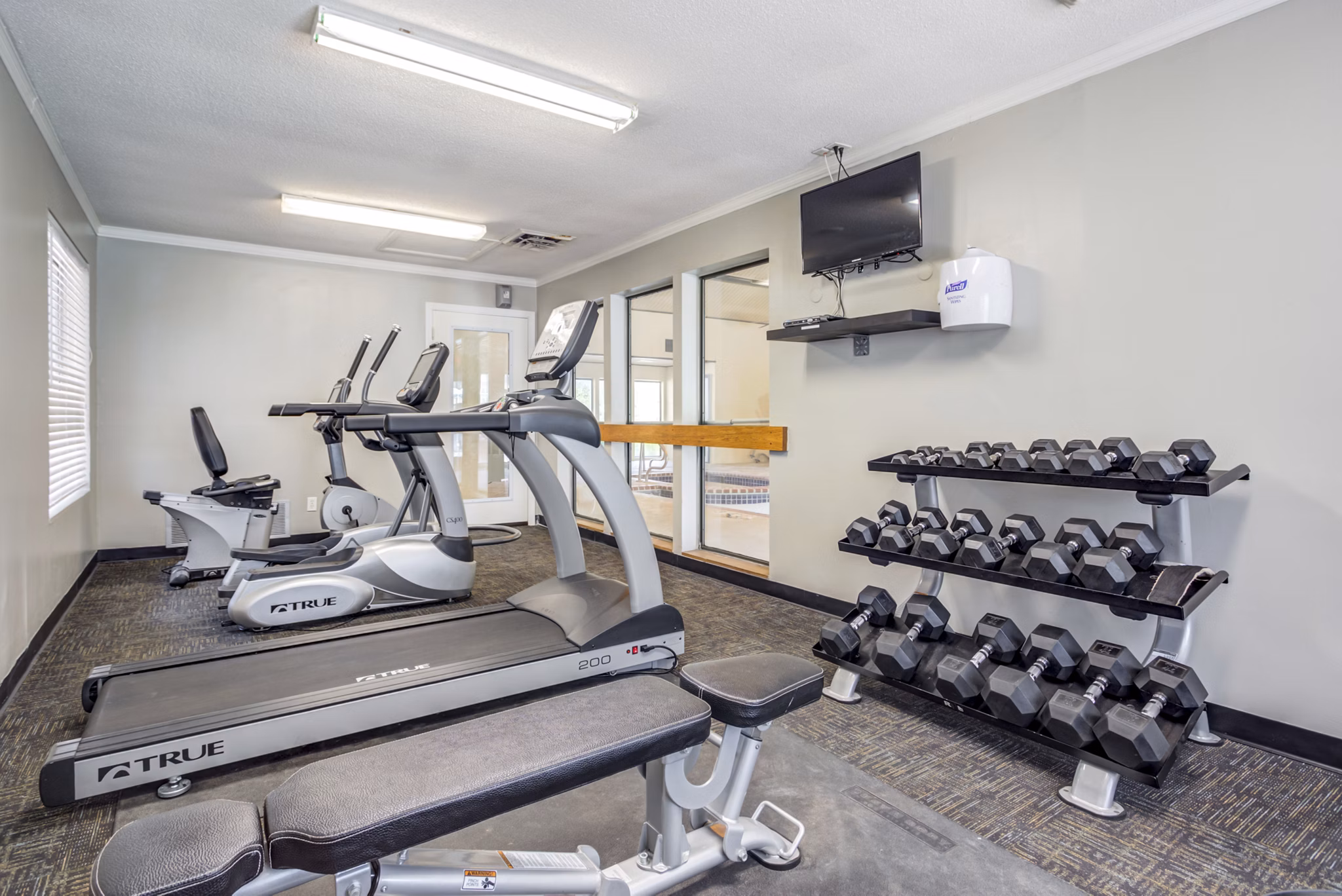 Modern fitness center with state-of-the-art equipment at Sun River Village Apartments
