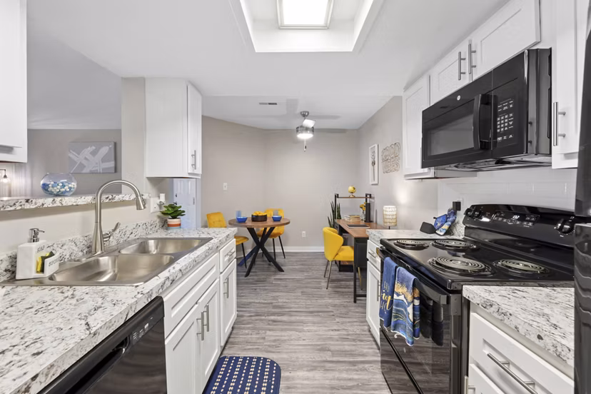 Kitchen featuring modern appliances and granite countertops in Sun River Village Apartments