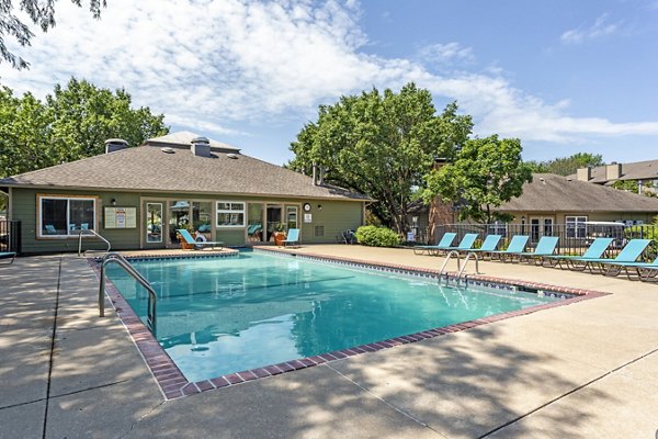 Tranquil swimming pool at Sun River Village Apartments featuring surrounding lush greenery