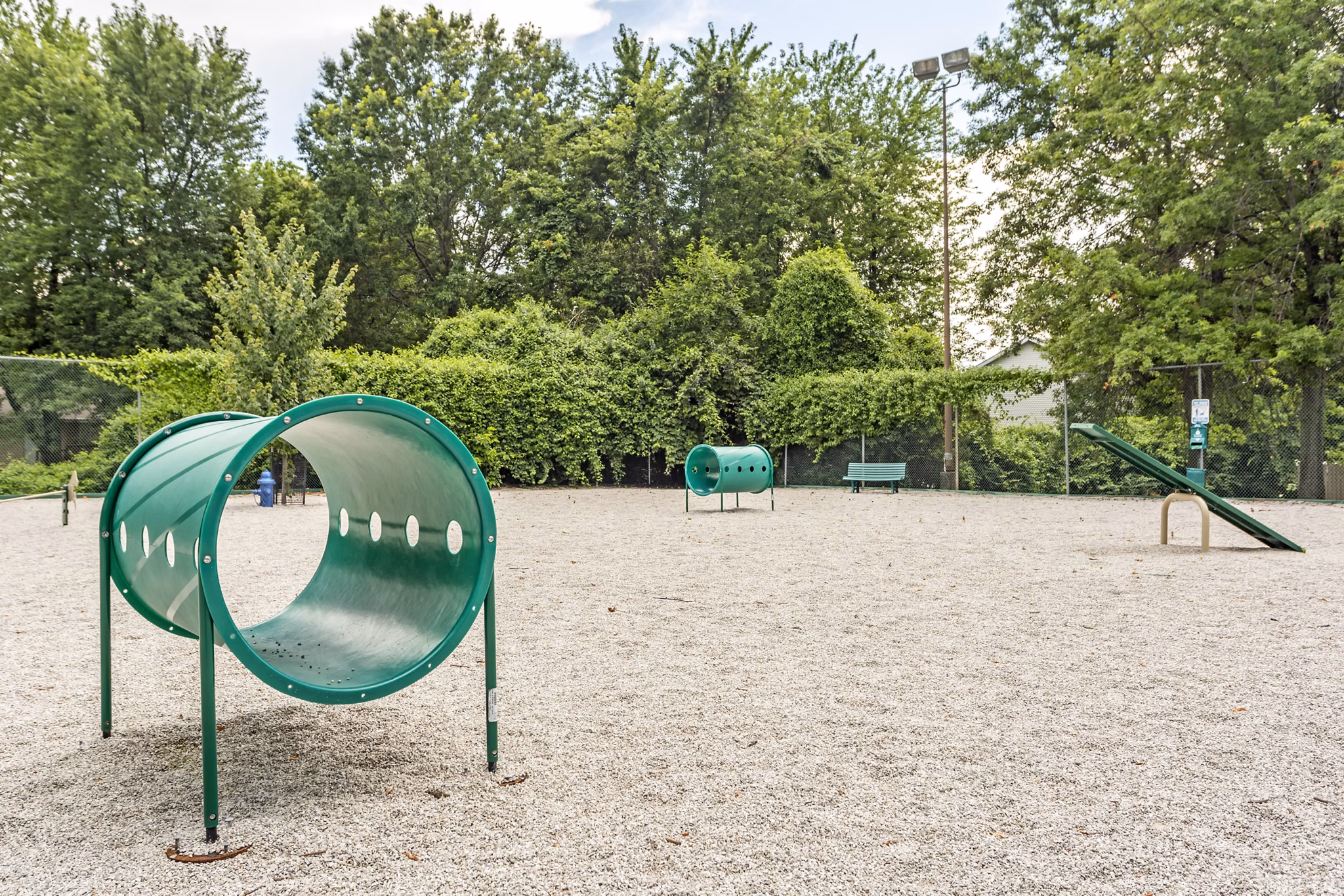 Dog park with agility course features at Sun River Village Apartments