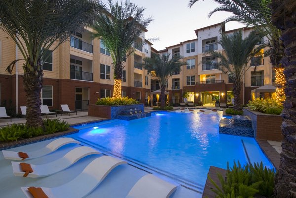 Sleek outdoor pool with lounge chairs at Domain West Apartments