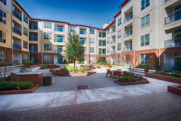 Relaxing courtyard featuring lush greenery and seating areas at Domain West Apartments