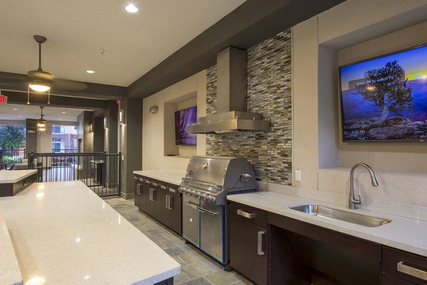 Outdoor grill area with modern seating at Domain West Apartments