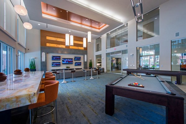 Game room with pool tables and lounge seating at Domain West Apartments, Houston, offering luxury leisure space