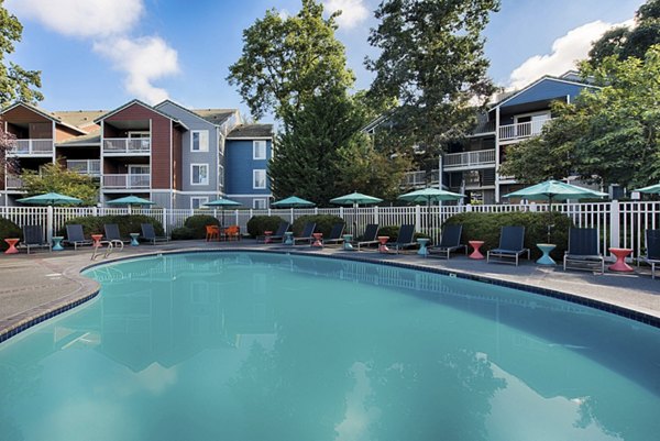 Pool with lounge chairs at Canyon Creek Apartments, a luxury community offering upscale amenities and modern living spaces in a serene setting