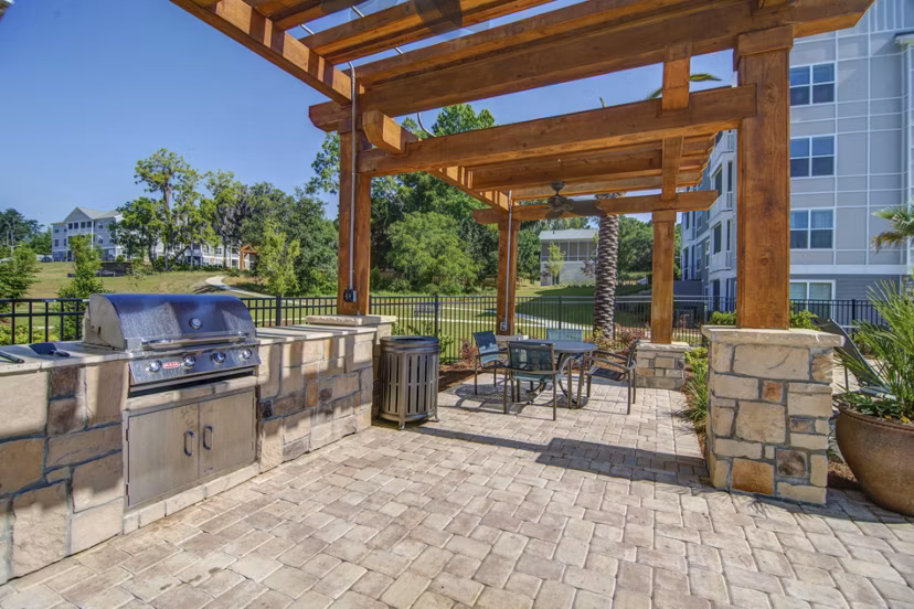 Grill area with seating and shade at Capital Place at Southwood Apartments