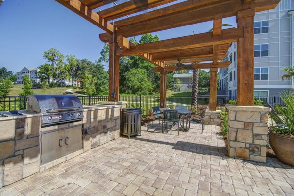 Grill area with seating and shade at Capital Place at Southwood Apartments