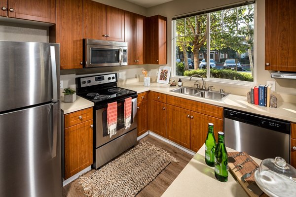 Modern kitchen featuring stainless steel appliances and granite countertops at Montiavo Apartments