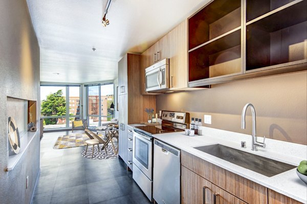Modern kitchen with stainless steel appliances at Cue Apartment Homes, offering luxury living in a prime location