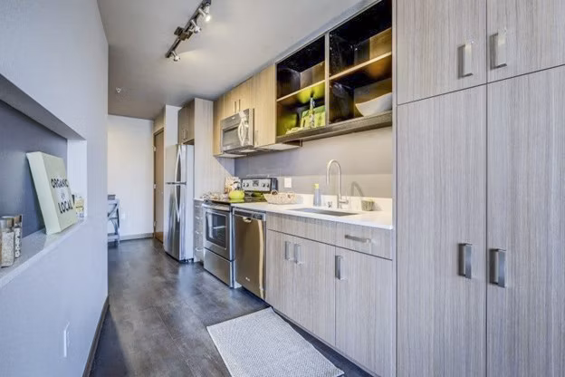 Modern kitchen with sleek appliances and granite countertops at Cue Apartments