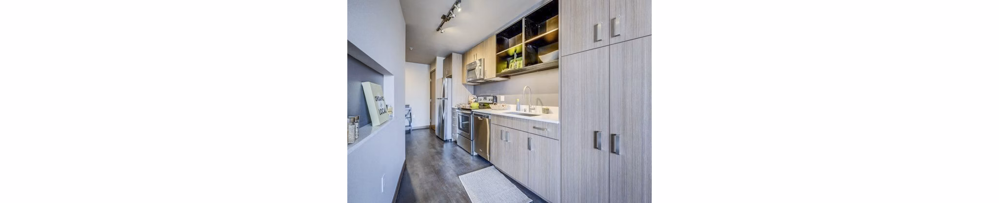 Modern kitchen with sleek appliances and granite countertops at Cue Apartments
