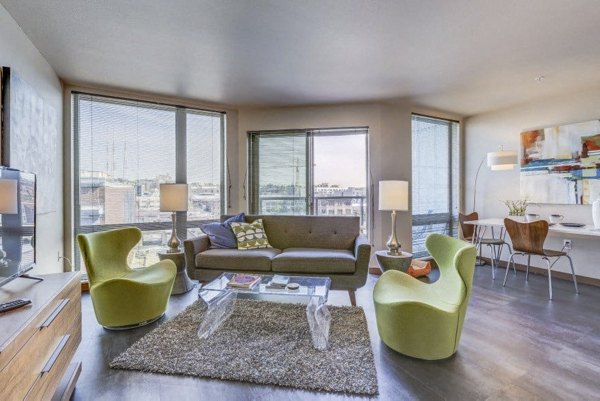 Contemporary living room with sleek furnishings and natural light at Cue Apartments