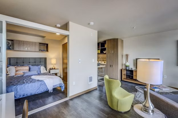 Living room with modern decor and natural light in Cue Apartments, a luxury Greystar property