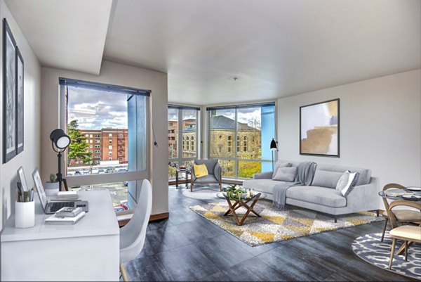 Modern home office and cozy living room at Cue Apartments, featuring stylish furnishings and ample natural light