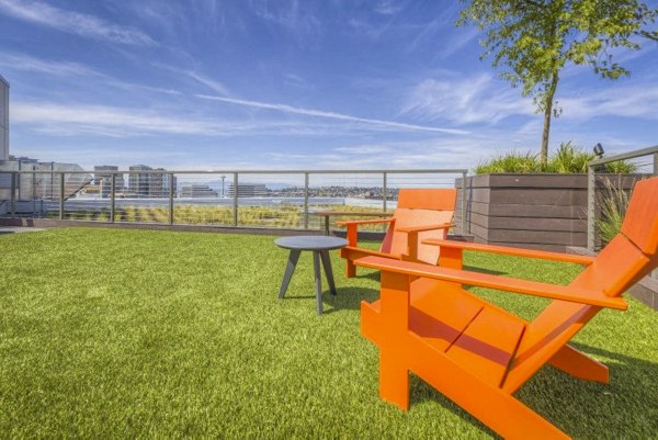 Patio with modern furniture at Cue Apartments offering stylish outdoor relaxation space