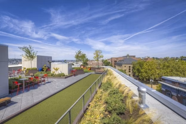 Balcony with cozy seating area at Cue Apartments, offering urban luxury living with city views