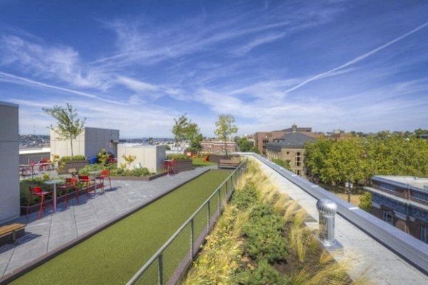 Balcony with cozy seating area at Cue Apartments, offering urban luxury living with city views
