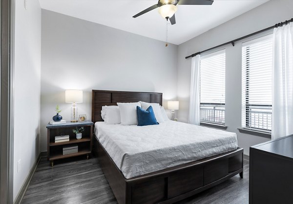 Spacious bedroom with modern furnishings at The Kenzie at The Domain Apartments, offering luxury living in Austin, TX