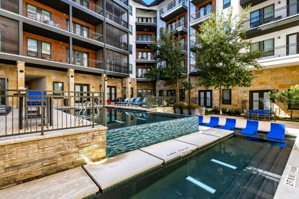 Resort-style pool with sundeck at The Kenzie at The Domain Apartments in Austin