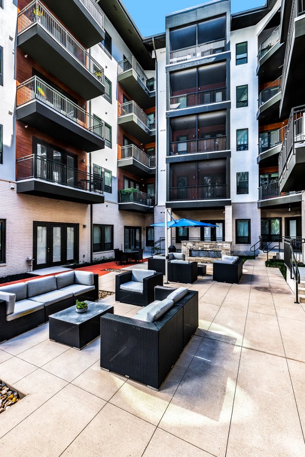 Courtyard with lush landscaping at The Kenzie at The Domain Apartments, featuring outdoor seating and modern design elements