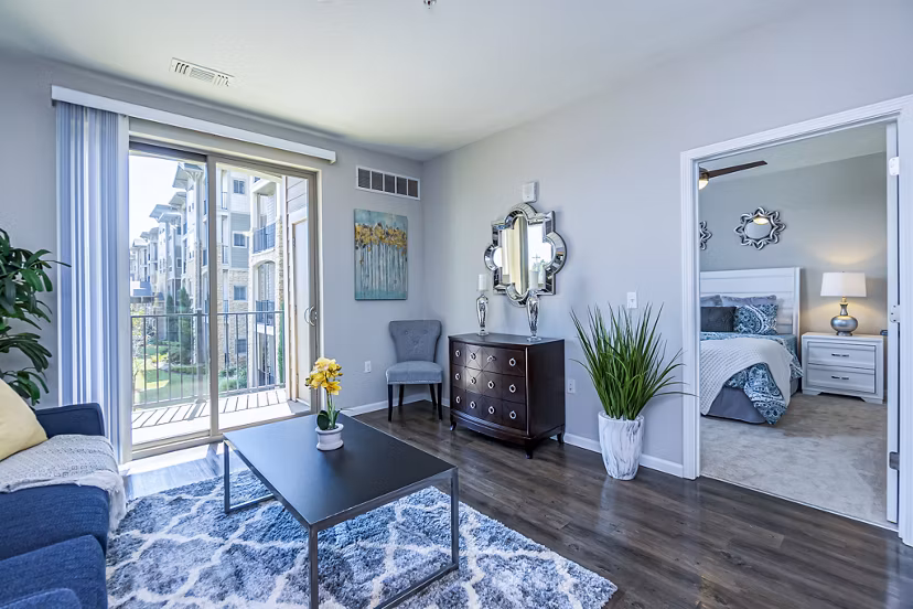 Spacious living room with modern furnishings and large windows in Album Quail Springs Apartments