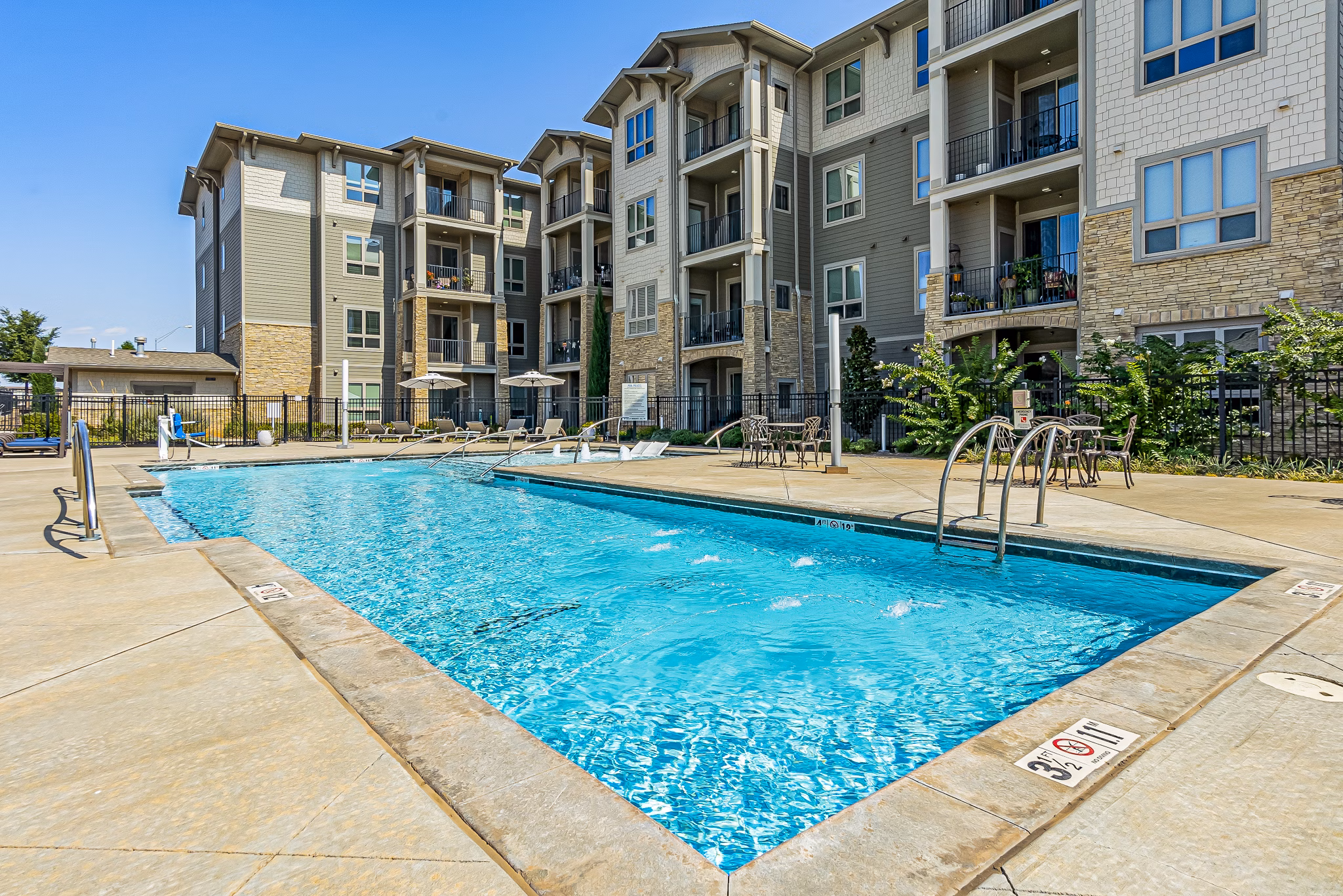 Outdoor pool with lounge chairs at Album Quail Springs Apartments