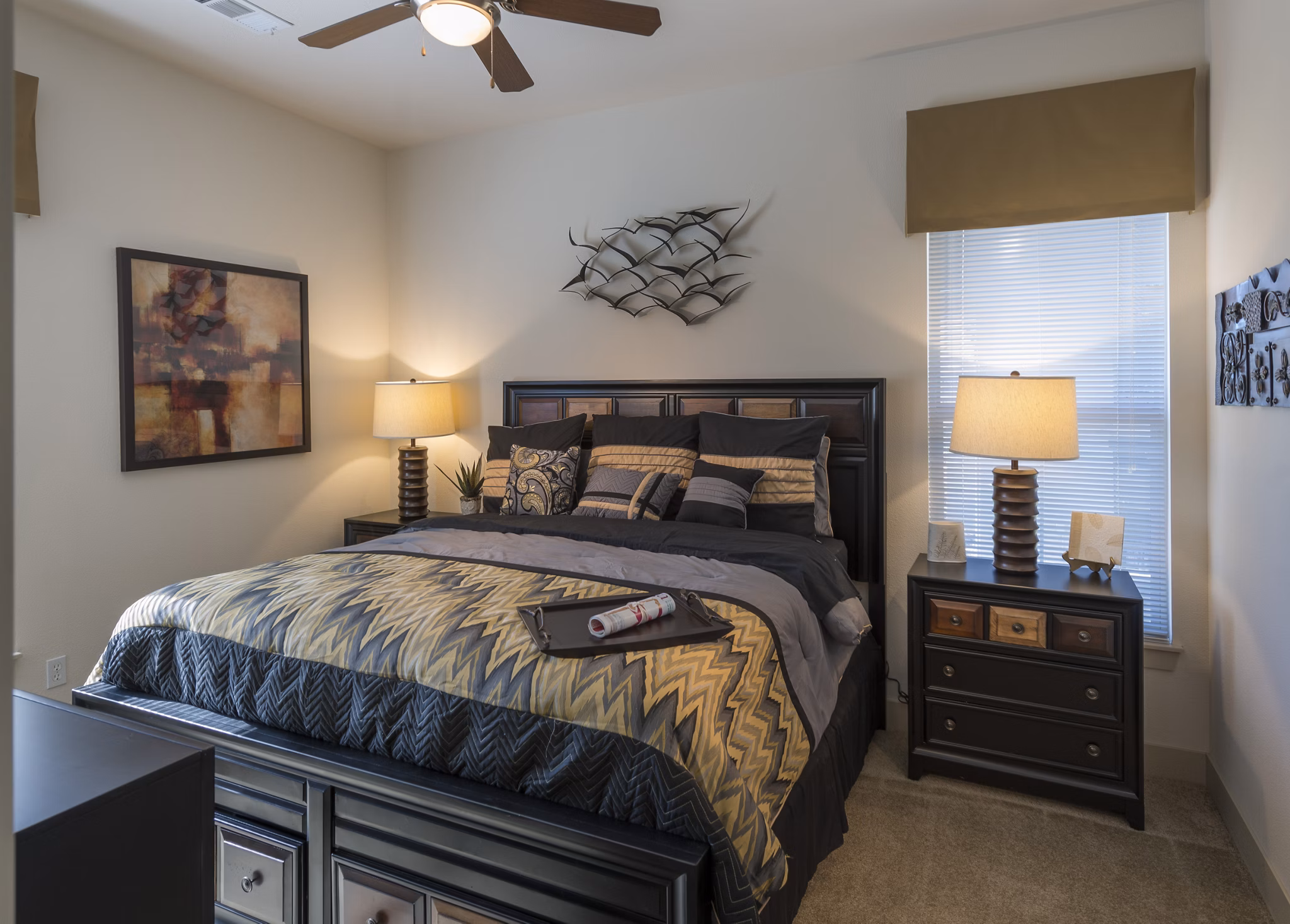 Cozy bedroom with stylish decor and large windows at Avana on the Platte Apartments, offering modern comfort in a luxury setting