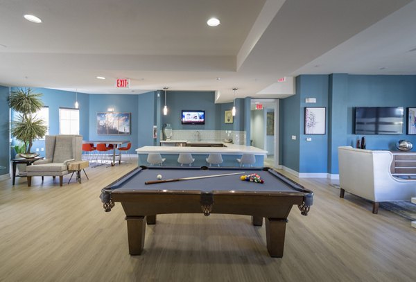 Clubhouse game room with billiards and seating at Avana on the Platte Apartments, a Greystar luxury community