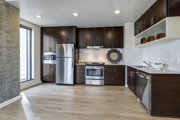 Modern kitchen with stainless steel appliances in Viktoria Apartments, a luxury Greystar property in a prime downtown location