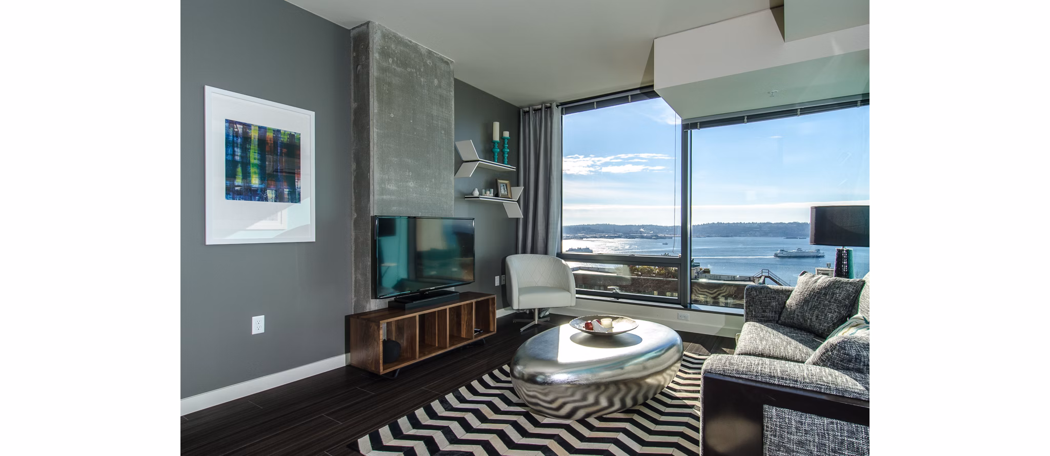 Spacious living room with modern furniture and city views at Viktoria Apartments
