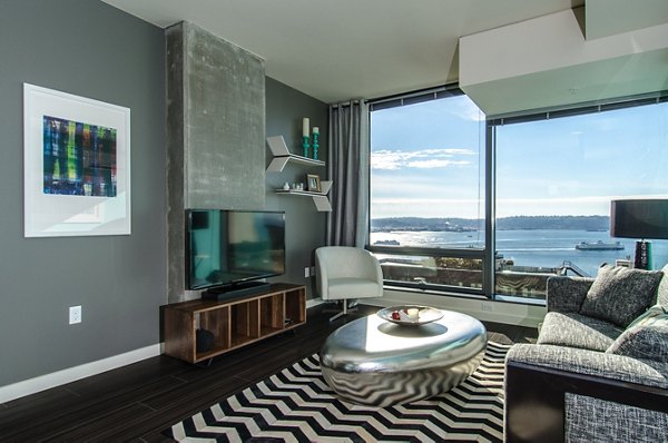 Spacious living room with modern furniture and city views at Viktoria Apartments