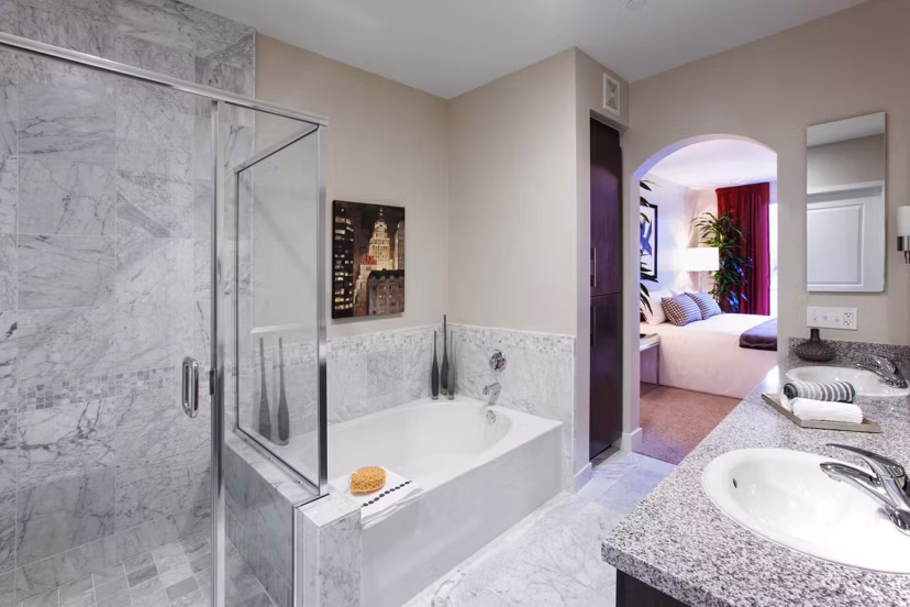 Elegant bathroom with marble countertops and large mirror in Carlyle Apartments