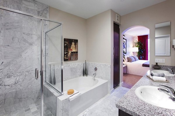 Elegant bathroom with marble countertops and large mirror in Carlyle Apartments