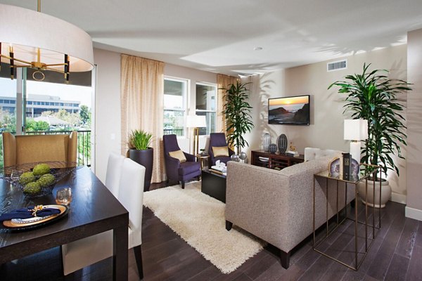 Spacious living room with modern decor and large windows in Carlyle Apartments, a Greystar luxury community