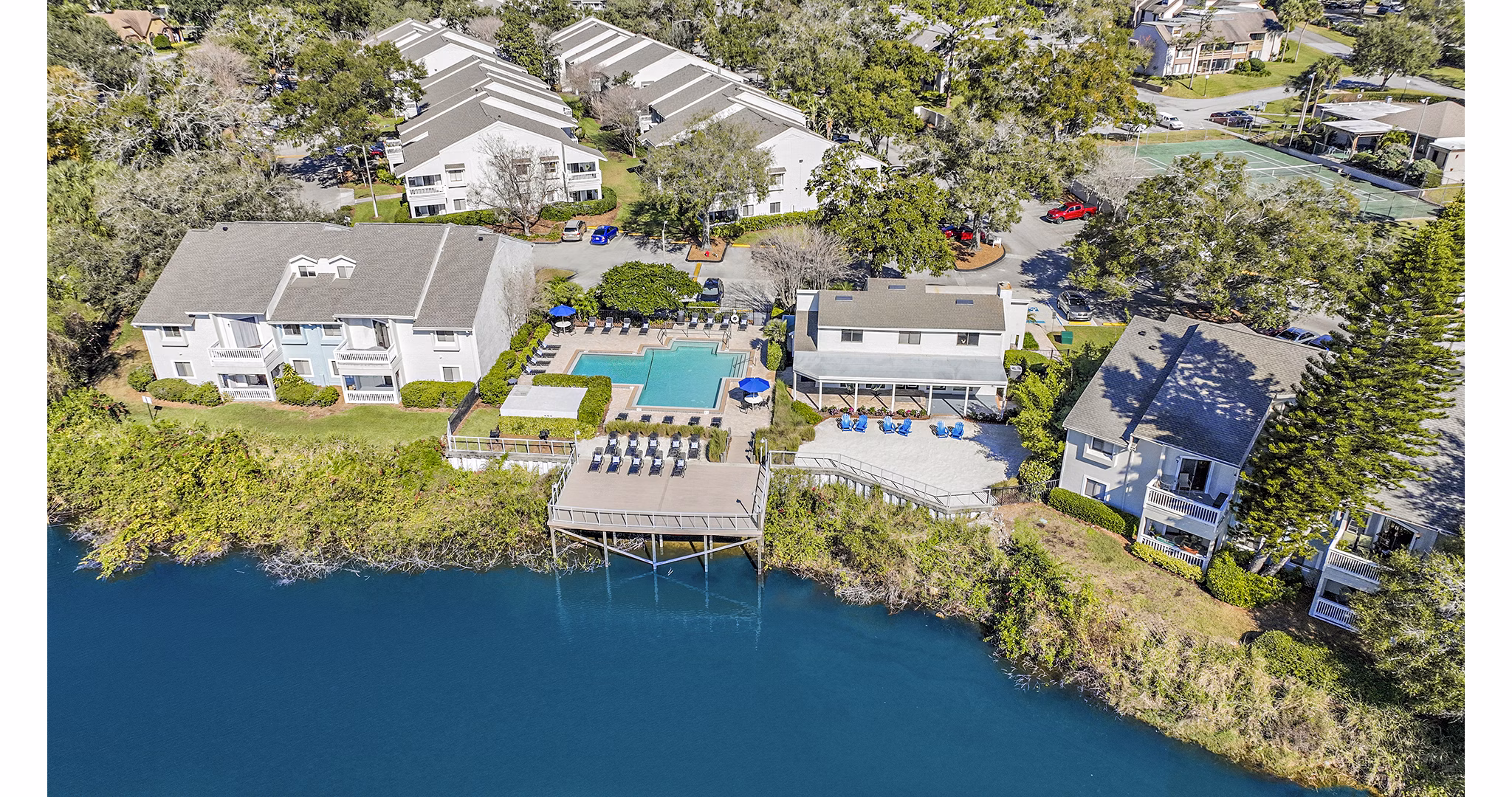 Resort-style swimming pool at Lakeshore at Altamonte Springs Apartments with lounge seating and lush landscaping