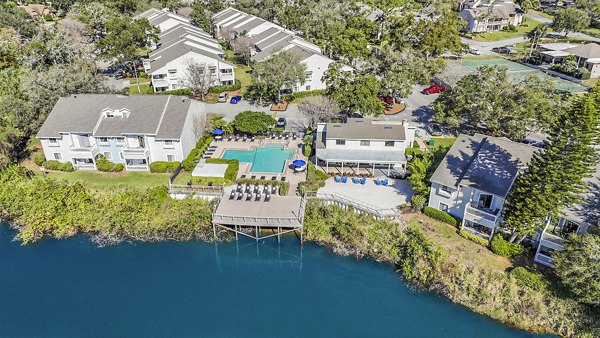 Resort-style swimming pool at Lakeshore at Altamonte Springs Apartments with lounge seating and lush landscaping