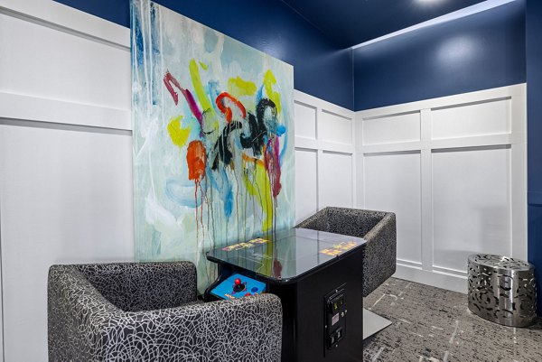 Cozy game nook featuring patterned chairs and an abstract painting in luxury apartments