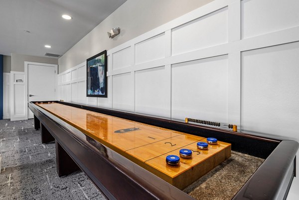 Game room with pool tables and arcade games at Junction Six Forks Apartments
