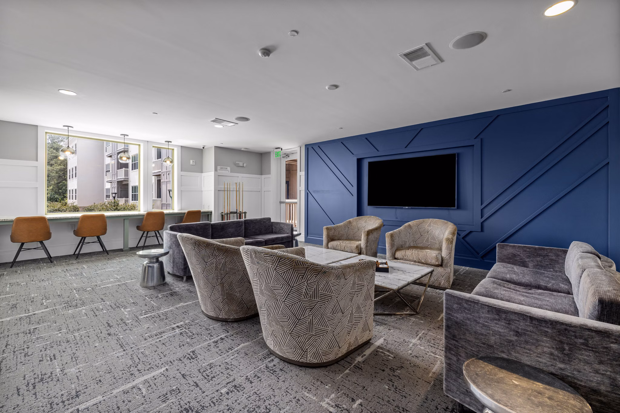 Modern clubhouse with lounge seating and game area at Junction Six Forks Apartments, perfect for social gatherings and events
