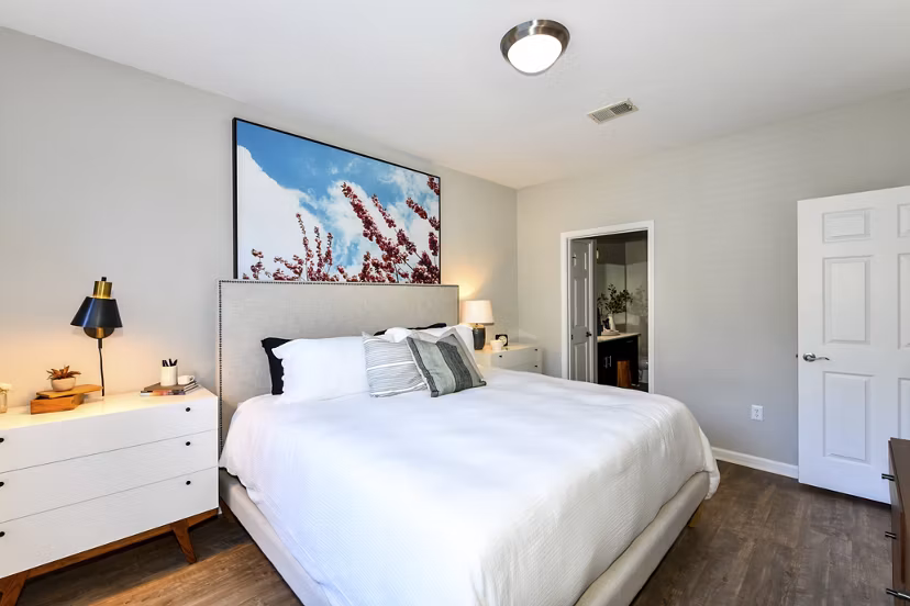 Bedroom with modern decor and large windows in Avana Ridenour Apartments