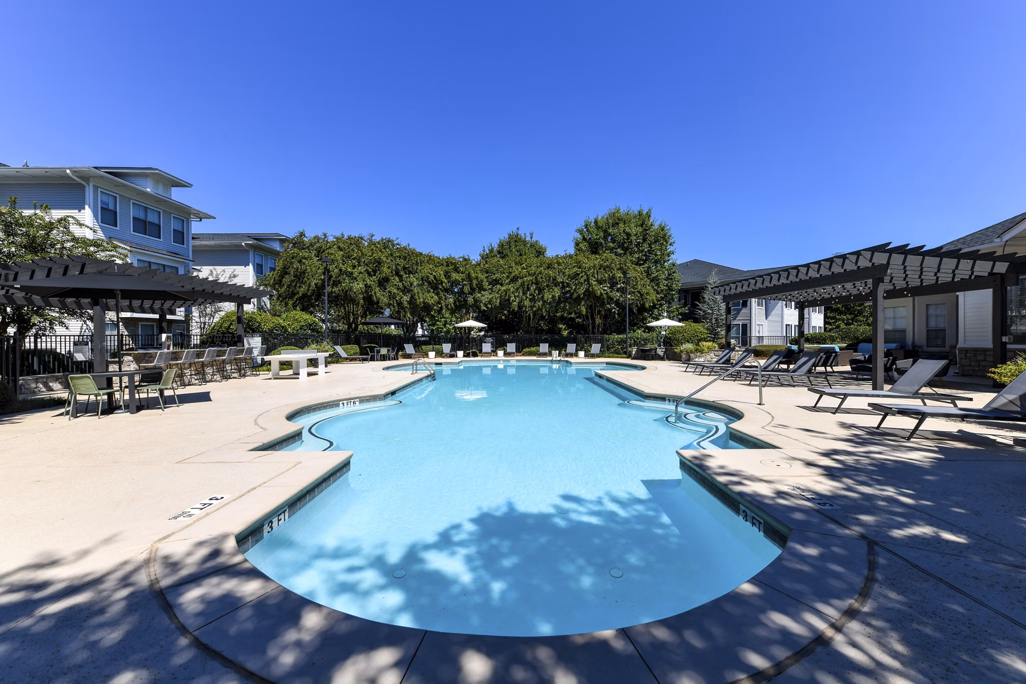 Resort-style pool with loungers at Avana Ridenour Apartments