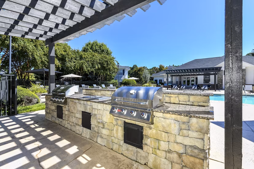Outdoor grill area with modern seating at Avana Ridenour Apartments