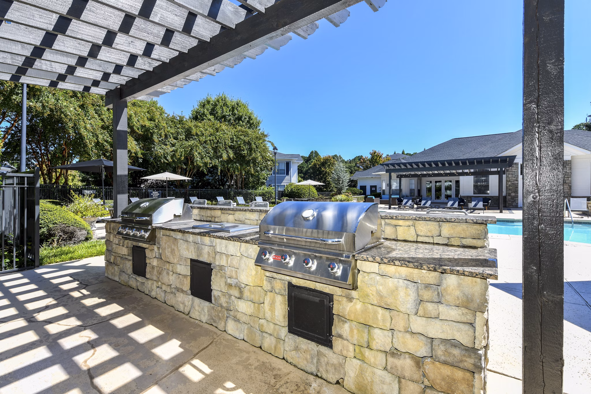 Outdoor grill area with modern seating at Avana Ridenour Apartments