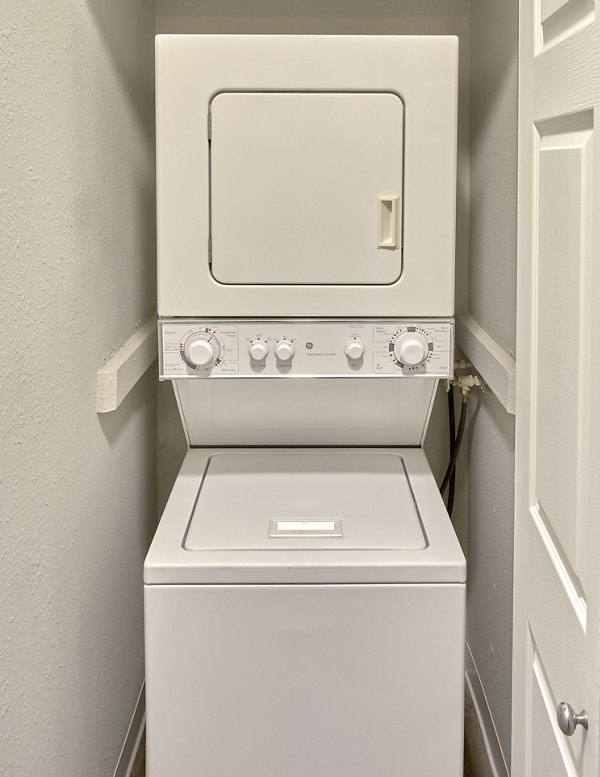 Laundry room with modern appliances and ample storage at Irwin Park Apartments