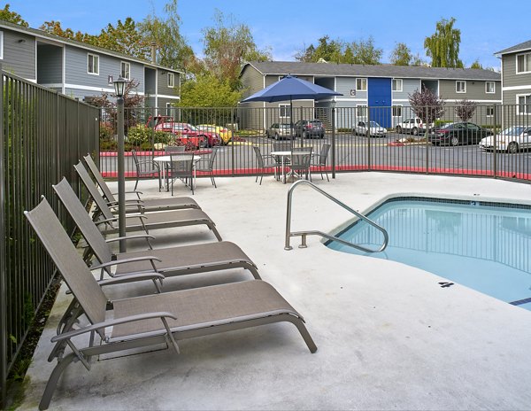 Modern pool with sun loungers at Irwin Park Apartments
