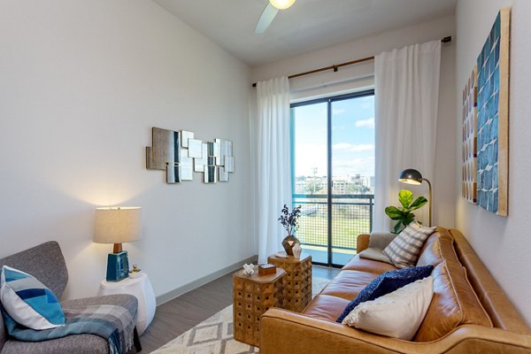 Spacious living room with modern decor and large windows in Azul Lakeshore Apartments
